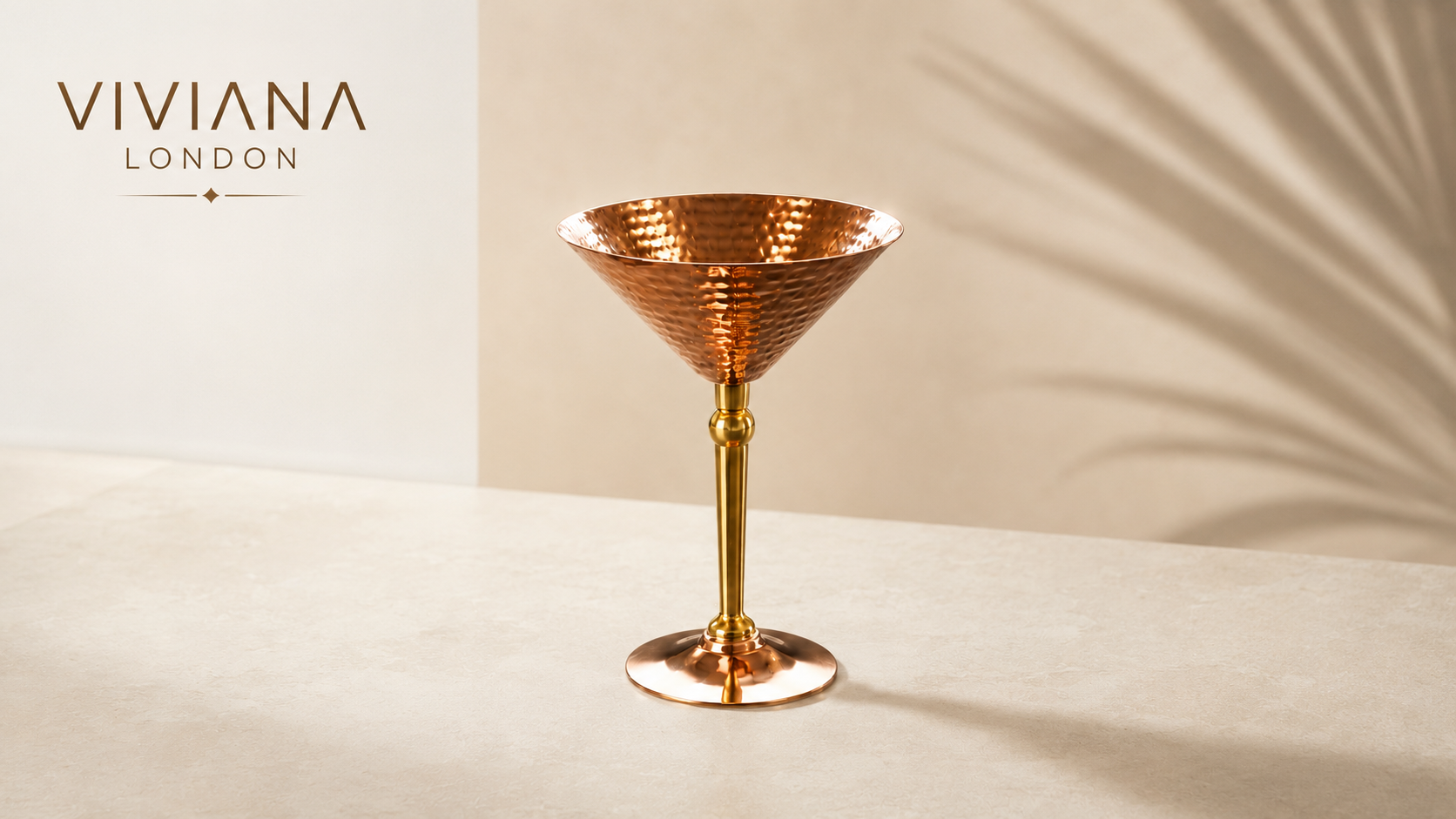 Handcrafted pure copper martini glasses with frosty finish on a dark marble bar counter Handcrafted pure copper martini glasses with frosty finish on a dark marble bar counter