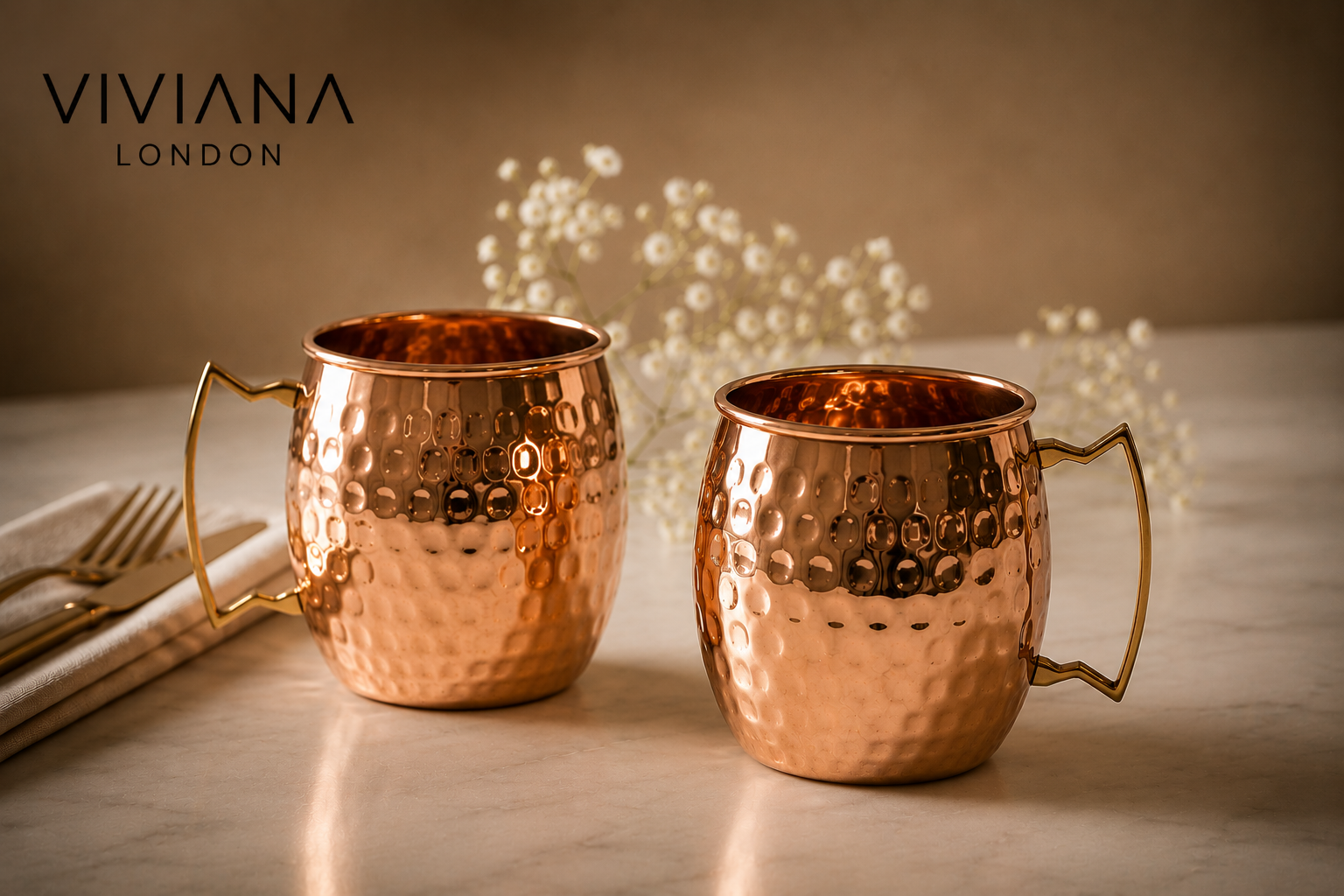 A hand-hammered pure copper Moscow Mule mug filled with an iced cocktail and fresh mint garnish on a dark bar surface.