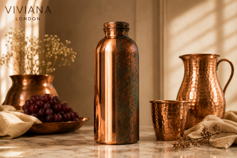Hand-hammered pure copper martini glass showing warm patina evolution styled on a wooden bar cart